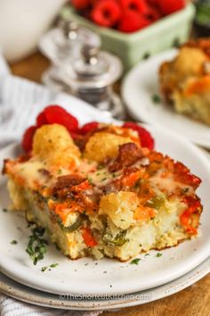 there is a piece of casserole on the plate with berries in the background