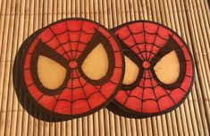 two spiderman cookies sitting on top of a bamboo mat