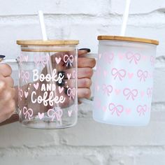 two people holding coffee mugs with pink bows and hearts on them, one has a straw in it