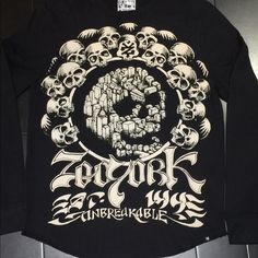 a black long sleeve shirt with skulls on it