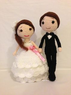 two crocheted dolls dressed in wedding attire, one is holding the other's hand