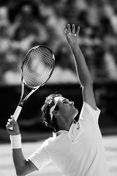 a man holding a tennis racquet up in the air with his hands raised