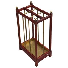 a small wooden cage with brass trimmings on the bottom and sides, sitting in front of a white background