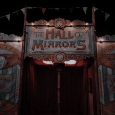 the hall of mirrors sign is lit up with lights and drapes on it's sides