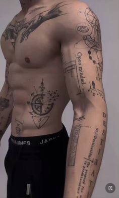 a man with lots of tattoos on his chest and arm is looking at the camera