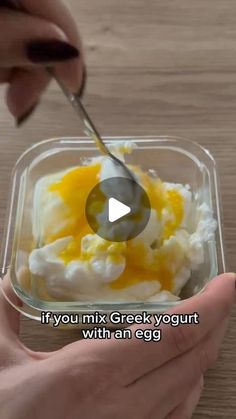 someone is spooning eggs into a small container with yogurt and an egg