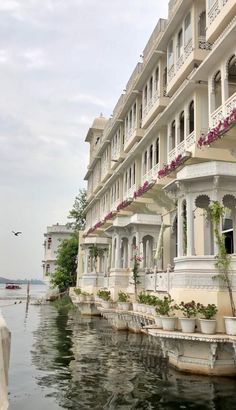 a row of white buildings sitting next to each other on the side of a body of water