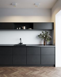 a modern kitchen with grey cabinets and white walls, an arrow pointing to the left