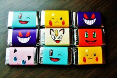 six different colored boxes with faces painted on them sitting next to each other in the middle of a wooden table