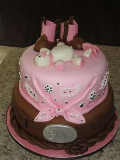 a pink and brown cake with boots on top