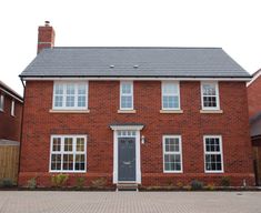 a red brick house with white windows and doors