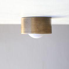 a light that is hanging from the ceiling with a white wall in the back ground