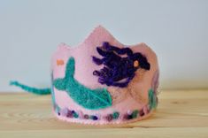 Pink Birthday Crown with Mermaid | Waldorf Inspired |Felted Birthday Hat | Girl Birthday Every birthday is a milestone in your child's life. Add some magic in the celebration and create memories that will last forever with this dreamy pink mermaid  birthday crown ! Inspired by the Waldorf pedagogy, this crown is completely handmade with lots of love and care for your beloved one! Let the mermaids take you under the sea and discover the treasures of the ocean... | DIMENSIONS | Crown Length: 29cm / 11 inches Crown Height: 13 cm / 5 inches at the highest point Ribbon: About 25 cm /9,5  inches on each side Fits all head sizes as is tied with a braided ribbon. | MATERIALS | The base and design are made of 100% sheep wool, but since wool felt is a bit itchy, the backing is made of synthetic felt Mermaid Birthday Crown, Whimsical Adjustable Pink Crown, Whimsical Pink Crown For Birthday, Adjustable Pink Crown With Round Shape, Dreamy Birthday, Waldorf Birthday Crown, Braided Ribbon, Pink Mermaid, Felt Sheets