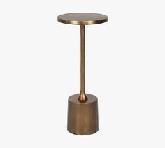 a small table with a metal base and a gold colored finish on the top, against a white background