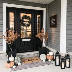 front porch decorated for fall with pumpkins and candles