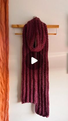 a purple scarf hanging on a wall