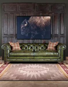 a living room filled with furniture and a large bison painting on the wall above it