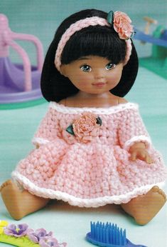 a crocheted doll sitting on the floor next to a toothbrush and comb