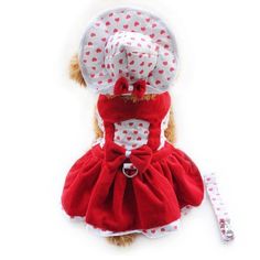 a dog dressed in a red and white polka dot dress with a hat on it's head