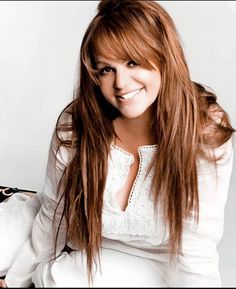 a woman with long red hair sitting down