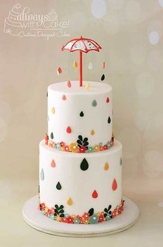 a three tiered cake with an umbrella decoration on it's top and bottom