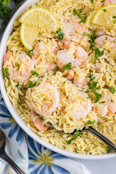 shrimp and rice with lemon wedges in a white bowl on a blue floral napkin