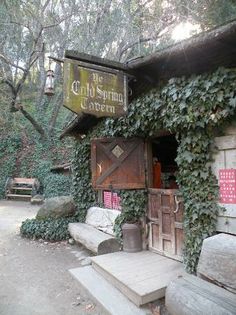 an old building covered in vines and ivys with a sign that reads the christmas tavern