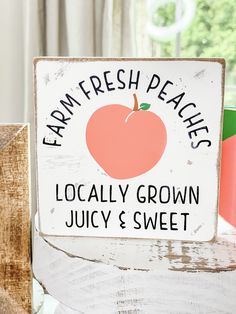 a sign that says farm fresh peaches locally grown juicy and sweet on it's side