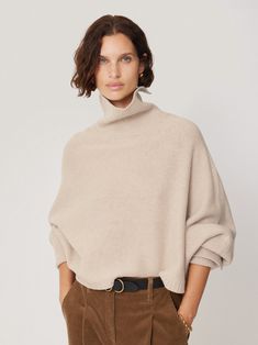 A unique fusion of a poncho and a jumper and crafted with luxurious merino wool, this piece features a distinctive design where half the sleeve remains fixed. The polo neck offers versatility with slit detail to fold up or down depending on your look. The boxy cropped silhouette allows for dynamic layering, inviting you to play with different looks by adding layers underneath. Whether paired with tailored trousers or casual denim, this sleeved poncho jumper instantly elevates any outfit, adding a touch of sophistication while keeping you warm. A timeless addition to your wardrobe, perfect for versatile, chic styling. Relaxed Trousers, Polo Neck, Tailored Trousers, Casual Denim, Jumpers For Women, To Play, Merino Wool, Quality Fabric, Sweaters & Cardigans