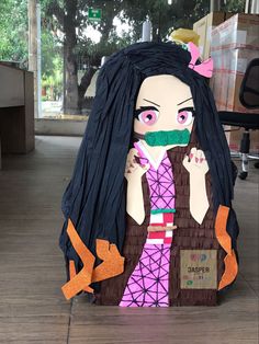 a cardboard cut out of a woman with black hair and green nose ring holding her mouth open