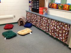 the dog is laying down on his bed in the middle of the room with other toys