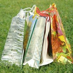 several bags are sitting in the grass on top of each other and one is empty