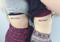 two women with matching tattoos on their stomachs, one has an arrow and the other has