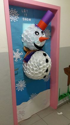 a snowman made out of golf balls on display in a pink frame with the words let it snow