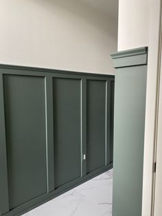 an empty room with green cabinets and marble flooring in the middle, along with white walls