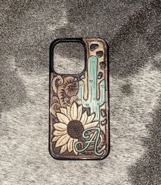 an iphone case with sunflowers and cactus design on it, sitting on a gray surface