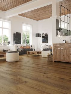 a living room filled with lots of furniture and wooden flooring on top of a hard wood floor