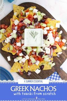 a wooden platter filled with nachos on top of a blue and white checkered table cloth