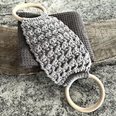 a crocheted cloth and wooden ring on top of a stone surface with wood rings