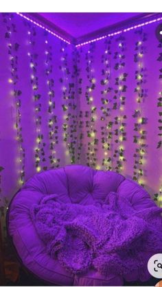 a purple chair sitting in front of a wall with lights