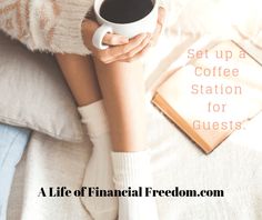 a woman holding a cup of coffee while sitting on a bed with her legs crossed