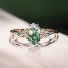 a green and white ring sitting on top of a white table next to a white surface