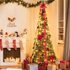 a decorated christmas tree in a living room next to a fireplace with presents under it