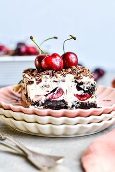 a piece of cake on a plate with cherries