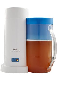 a coffee maker with a cup next to it on a white surface, and a blue lid