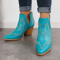 a close up of a person wearing blue cowboy boots with diamond embellishments