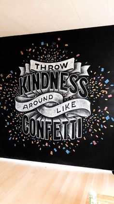 a blackboard with confetti written on it in front of a wall that says throw kindness around like confetti