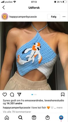 a woman wearing a crocheted crop top with an orange and white cat on it