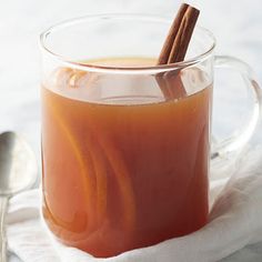 a glass mug filled with liquid and cinnamon sticks