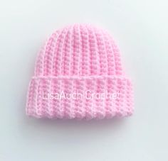 a pink knitted hat sitting on top of a white table